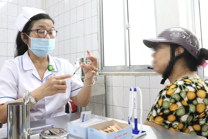 Chó cắn trẻ em, chủ nuôi phủi trách nhiệm- Ảnh 1. Người dân đến tiêm vắc xin phòng bệnh dại tại Bệnh viện Bệnh nhiệt đới (TP.HCM) - Ảnh: XUÂN MAI