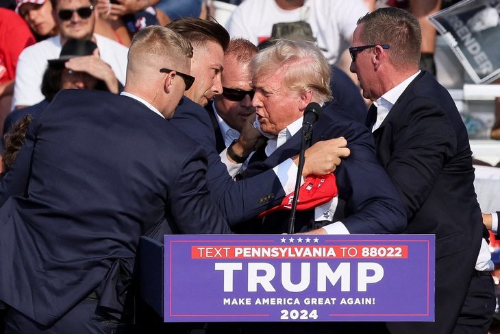 ‘Chúa phù hộ tổng thống Trump’- Ảnh 1. Ông Trump được các nhân viên mật vụ bao quanh và hỗ trợ sơ tán - Ảnh: REUTERS